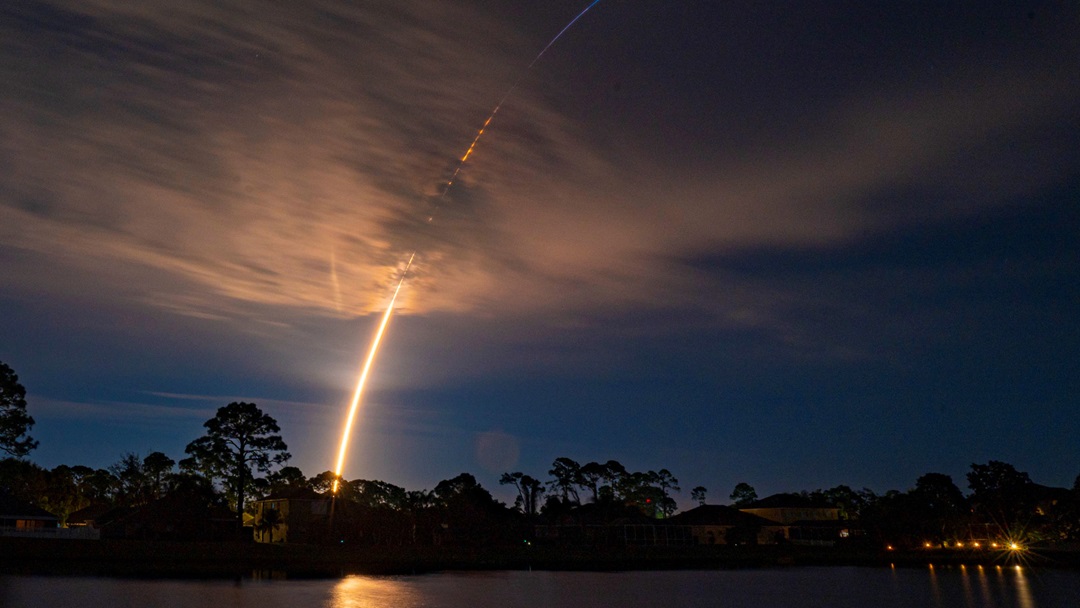 Rocket stream shown against dark sky landscape. 