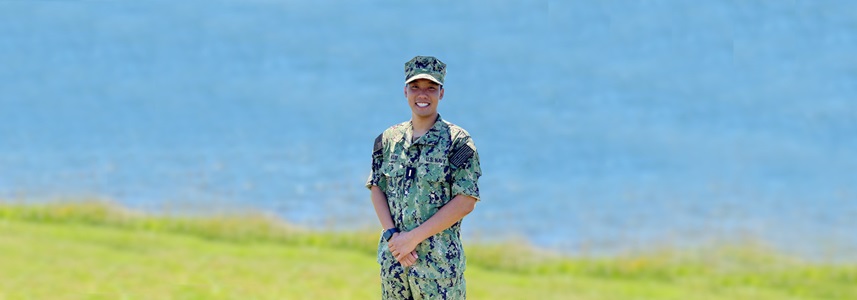 u.s. navy sailor posed in front of lake.
