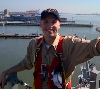 young man smiling on navy ship