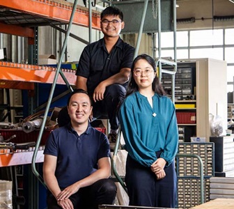 Three engineers posed and smiling together. 