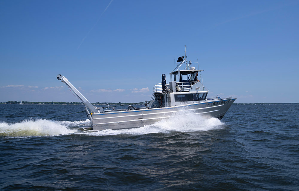 The Discovery, a 50-foot aluminum catamaran, motors out into the Chesapeake Bay to conduct maritime testing. 50-foot aluminum catamaran on water