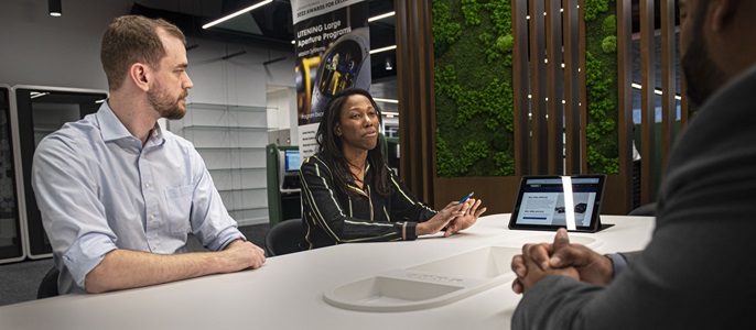 two people in office workroom at table 