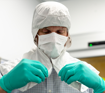 Image of man putting on clean room coverings.