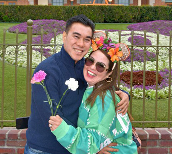 two people hugging and smiling with flowers