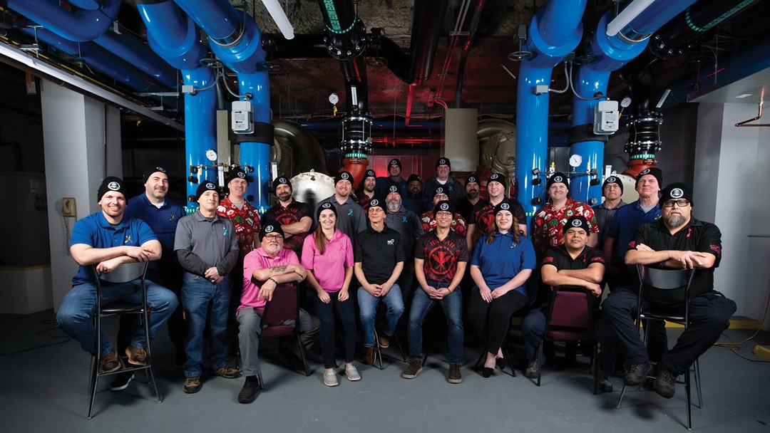 Large team sits in an industrial space.