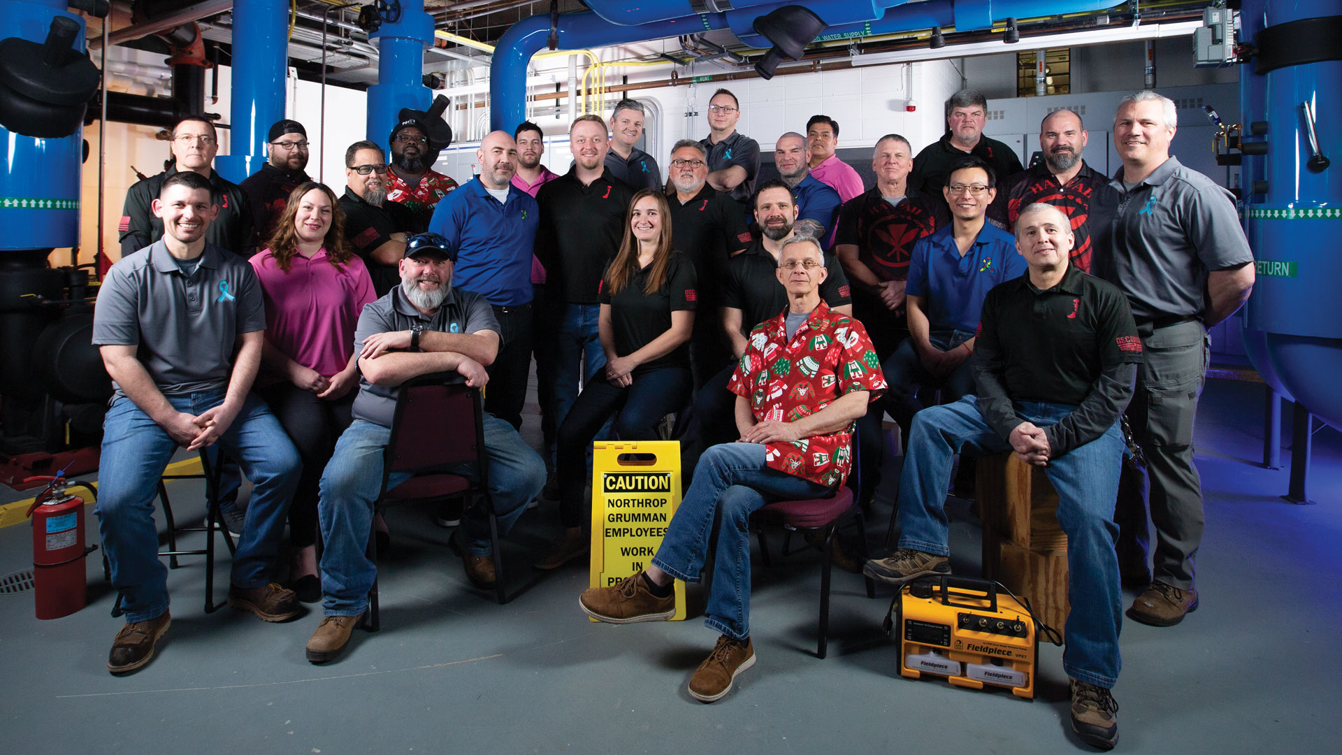 Large team sits in an industrial space.