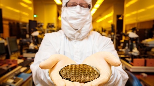 Person in white suit holding a circle chip