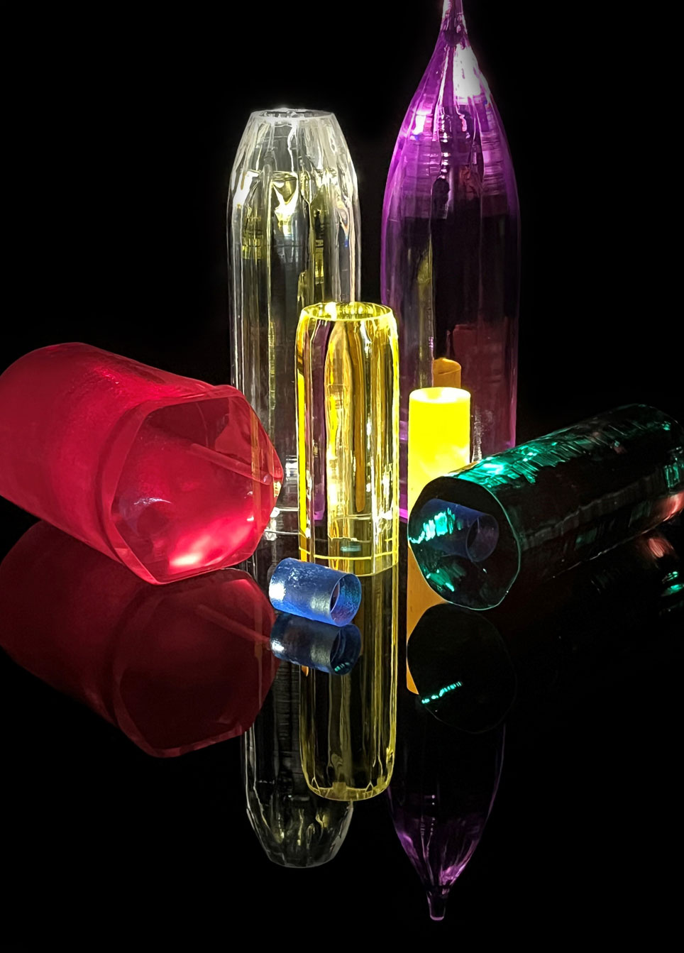 Crystals of various colors - including yellow, pink, green, purple and white - are positioned together and lit up.
