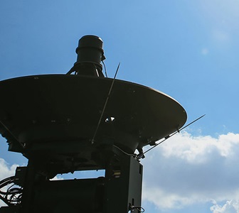 ground radar in front of blue sky.