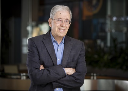 Older white man in business attire smiles