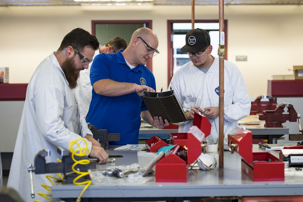 Group of three white males working on product