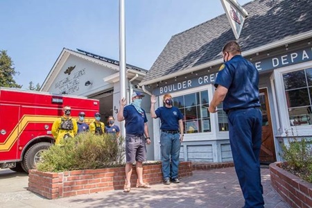 Two white men are sworn in as volunteer firefighters outside