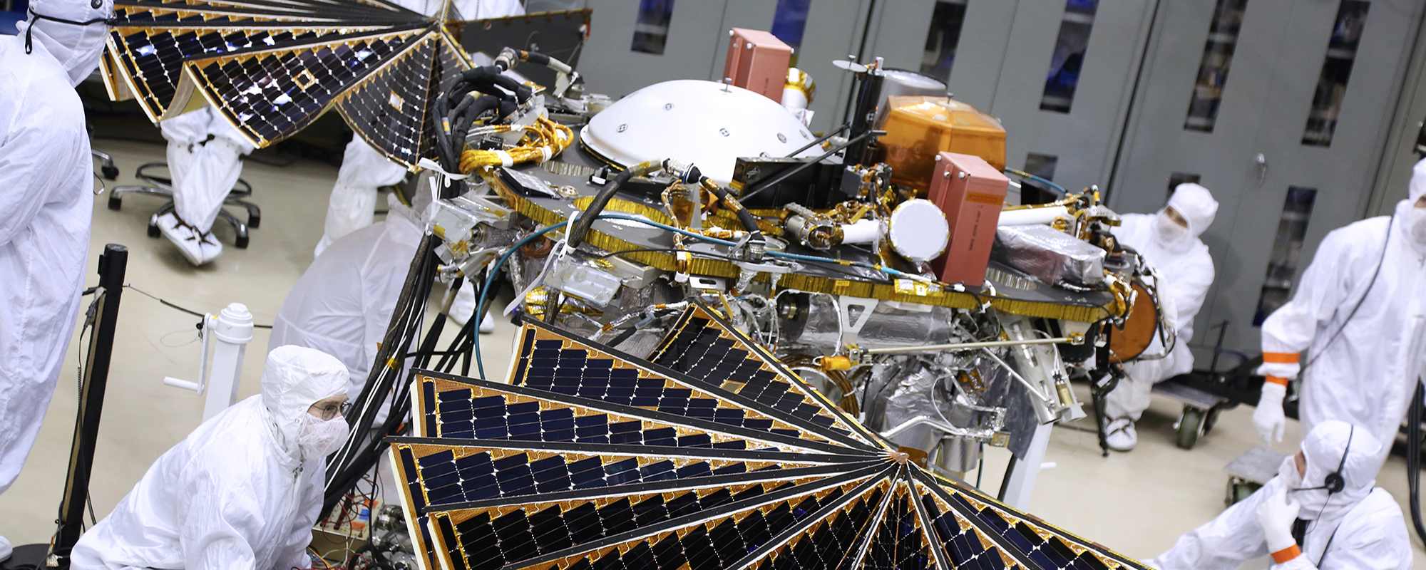 people working on spacecraft components