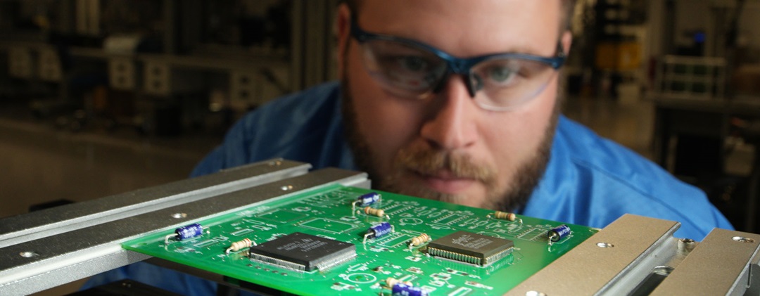 man wearing safety glasses looking at equipment