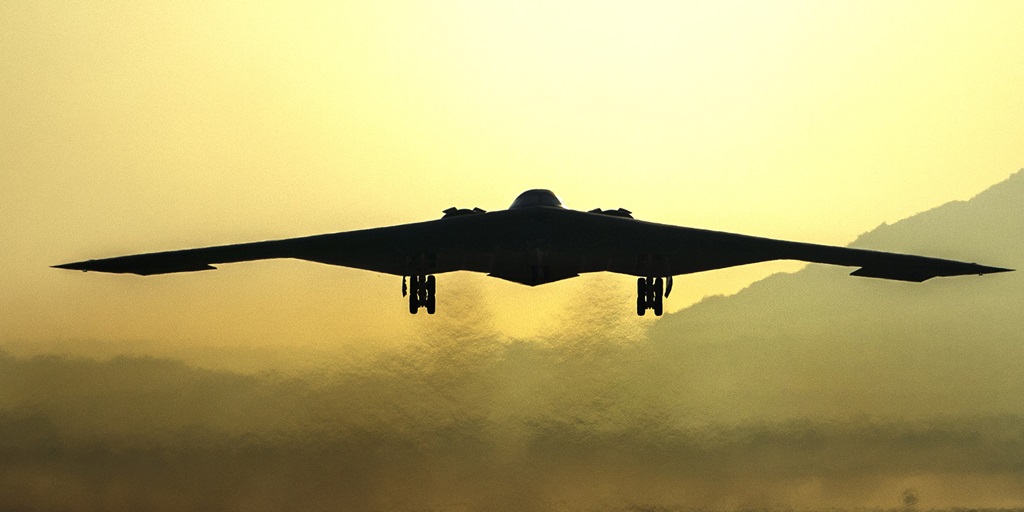 silhouette of an aircraft landing down to a runway