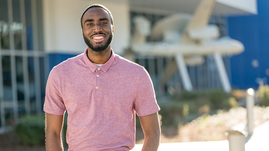 smiling Black man in pink polo shirt