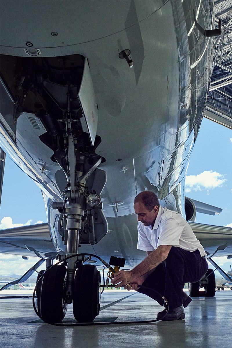 man checking tire on airplane