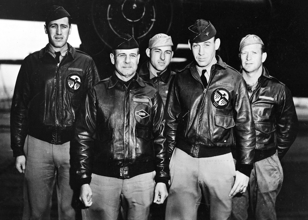 Five pilots standing in front of a plane for a group picture