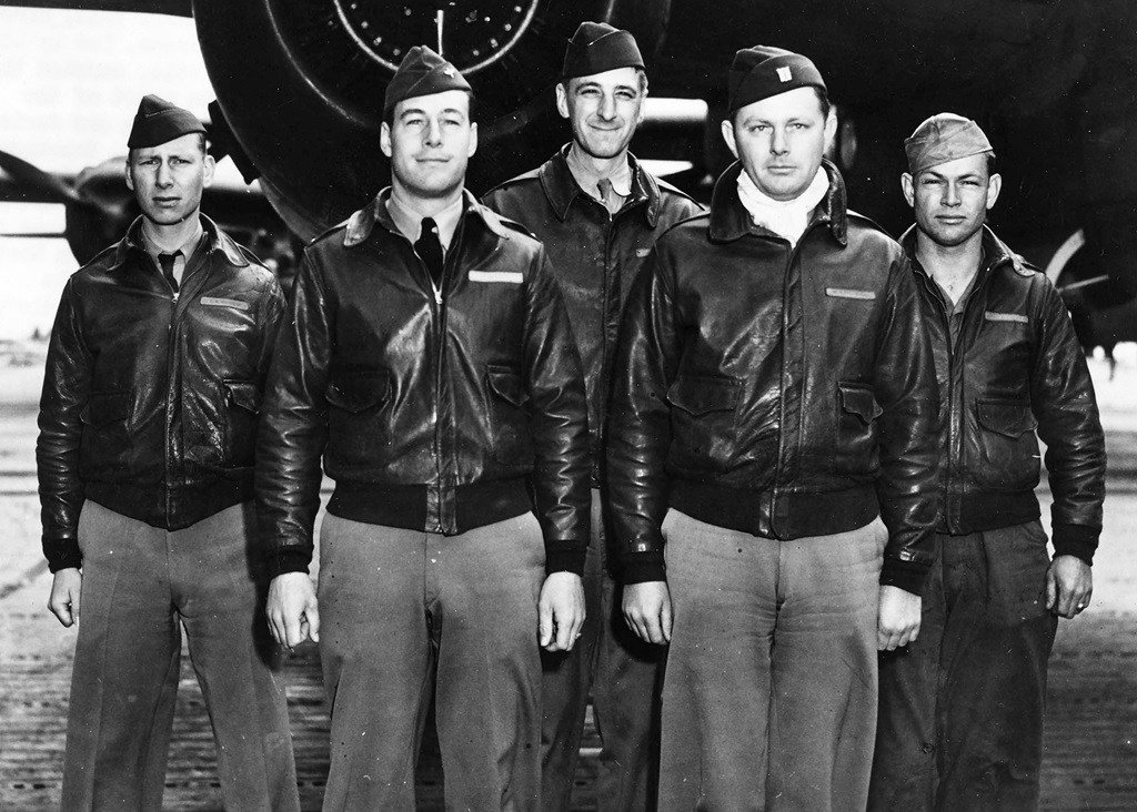 Five pilots standing in front of a plane for a group picture