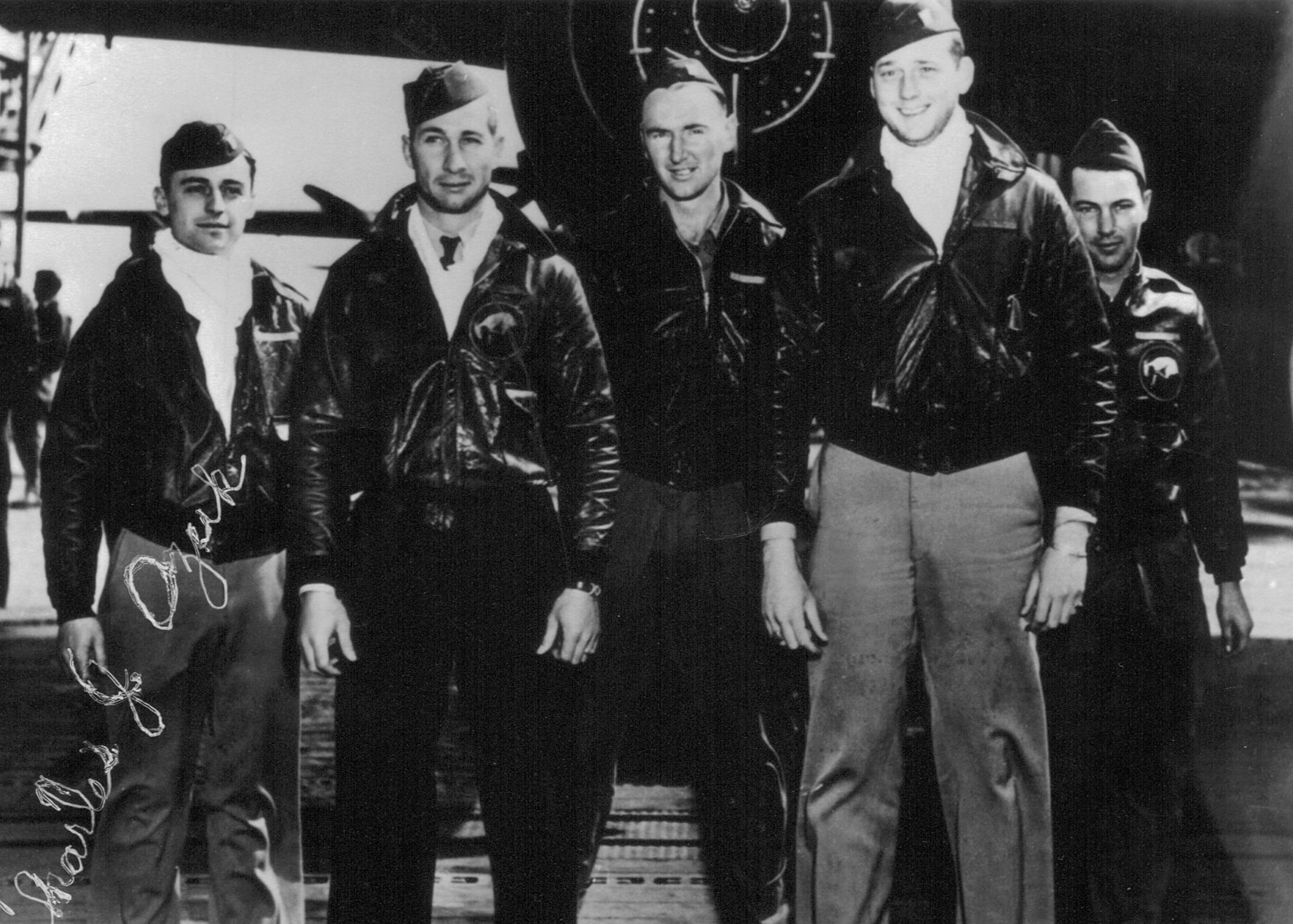 Five pilots standing in front of a plane for a group picture