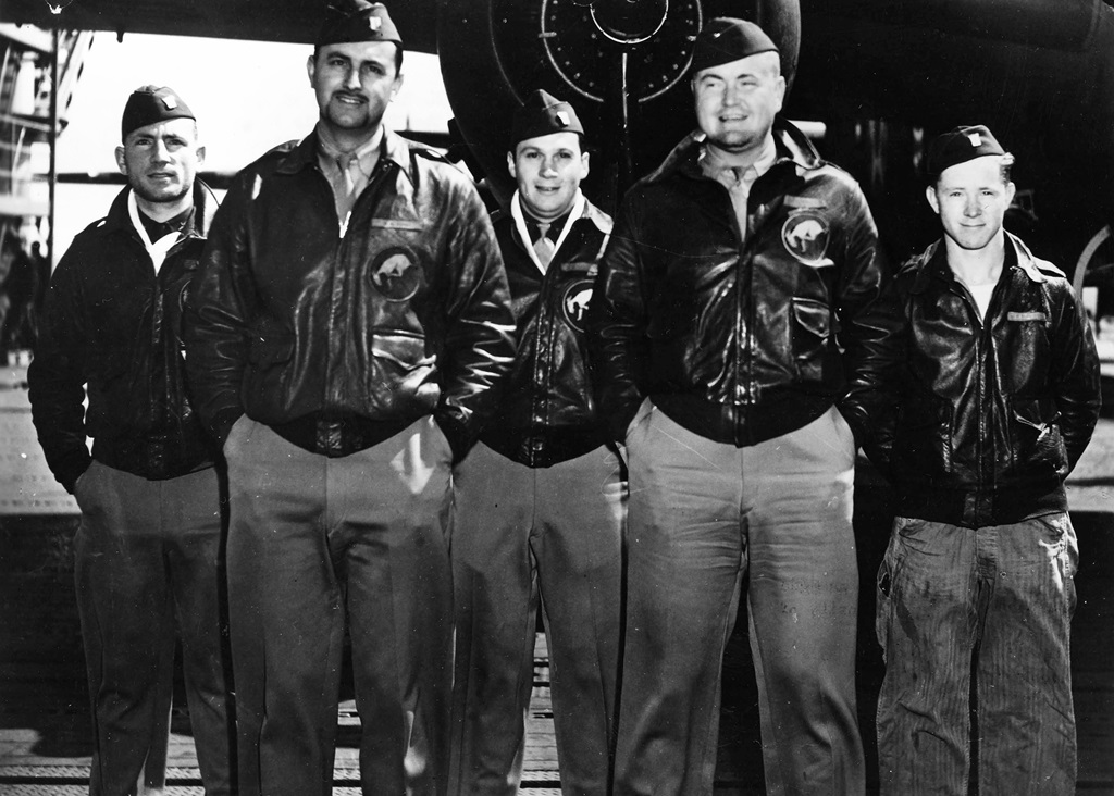 Five pilots standing in front of a plane for a group picture