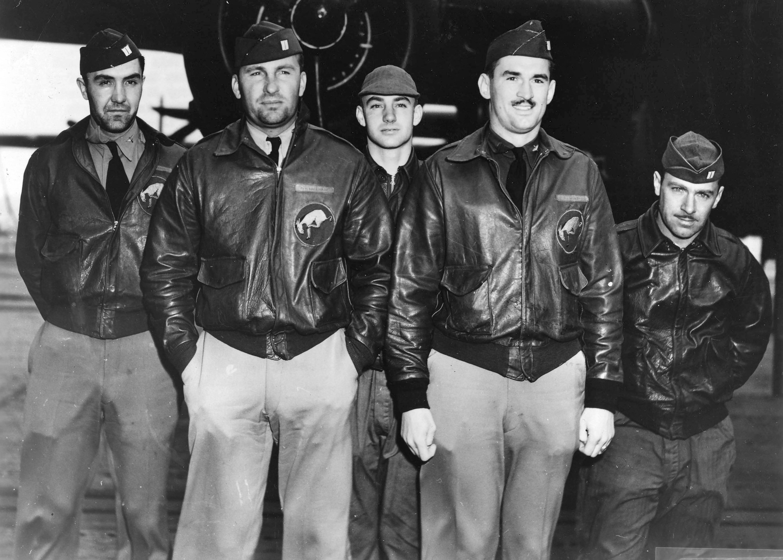 Five pilots standing in front of a plane for a group picture