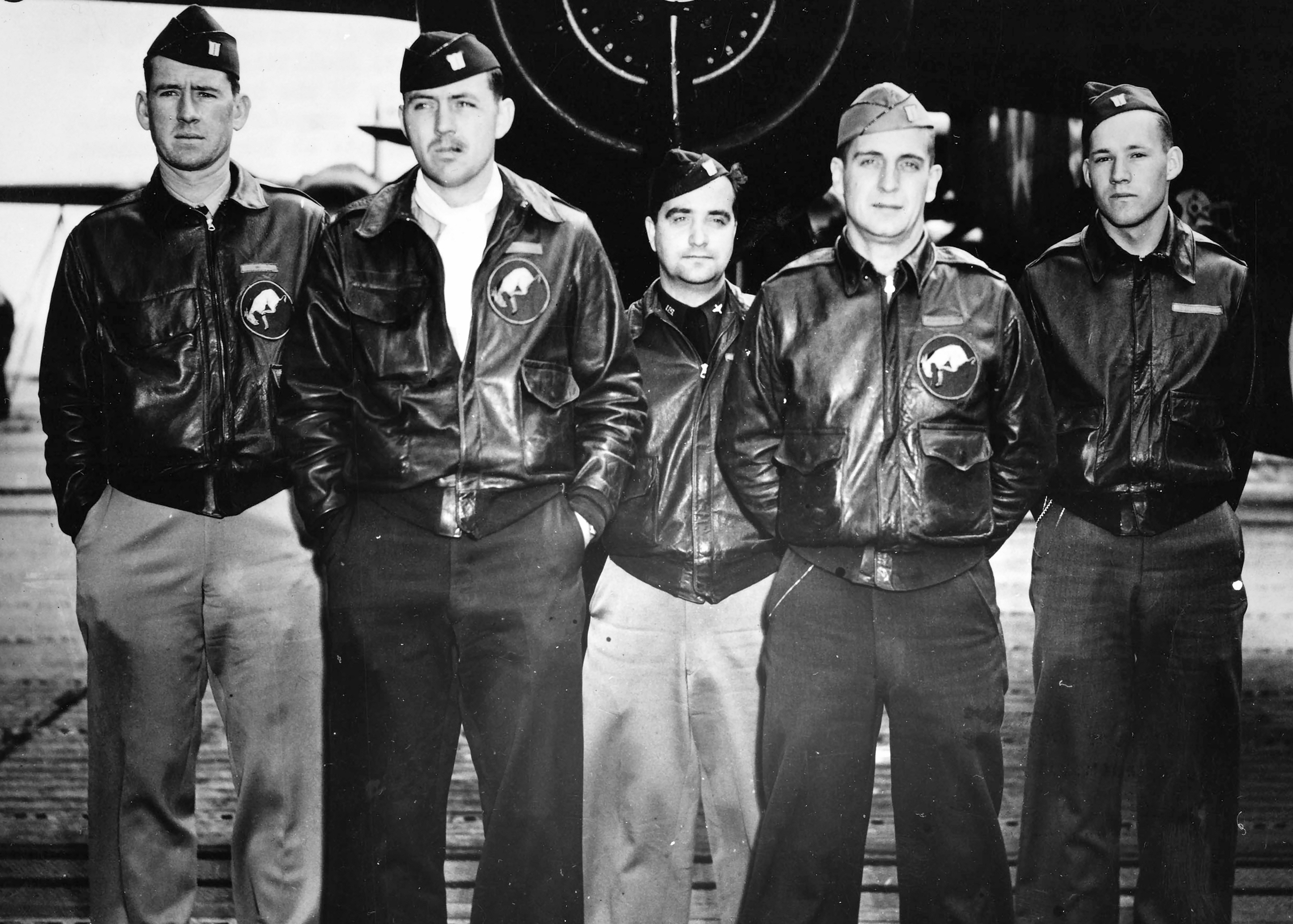 Five pilots standing in front of a plane for a group picture