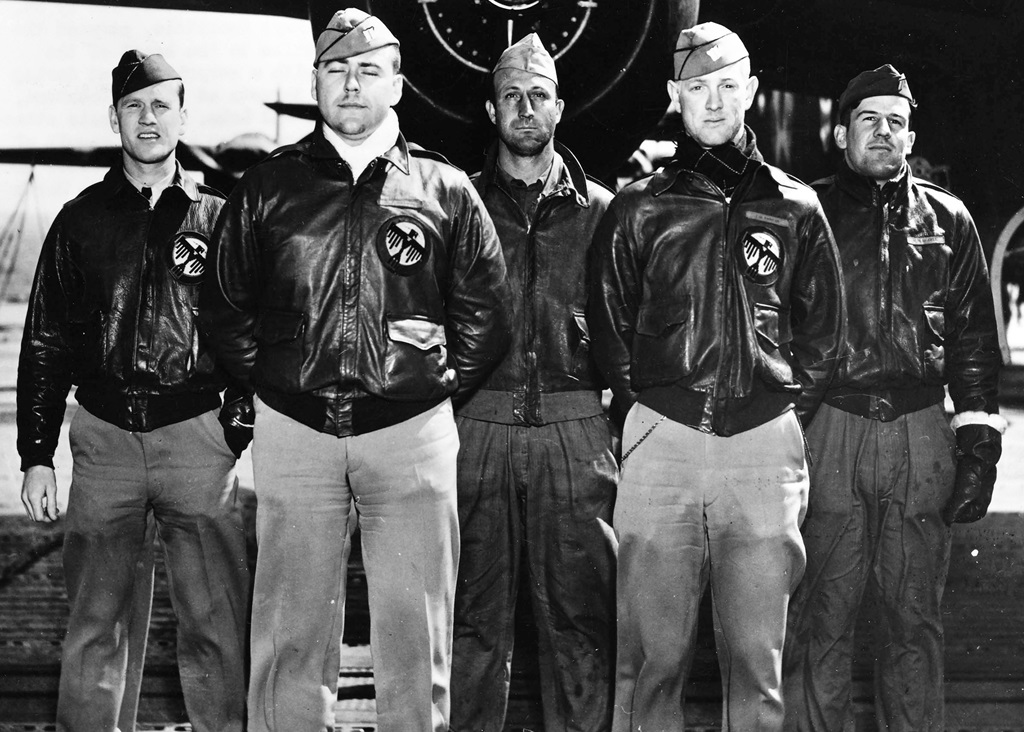 Five pilots standing in front of a plane for a group picture