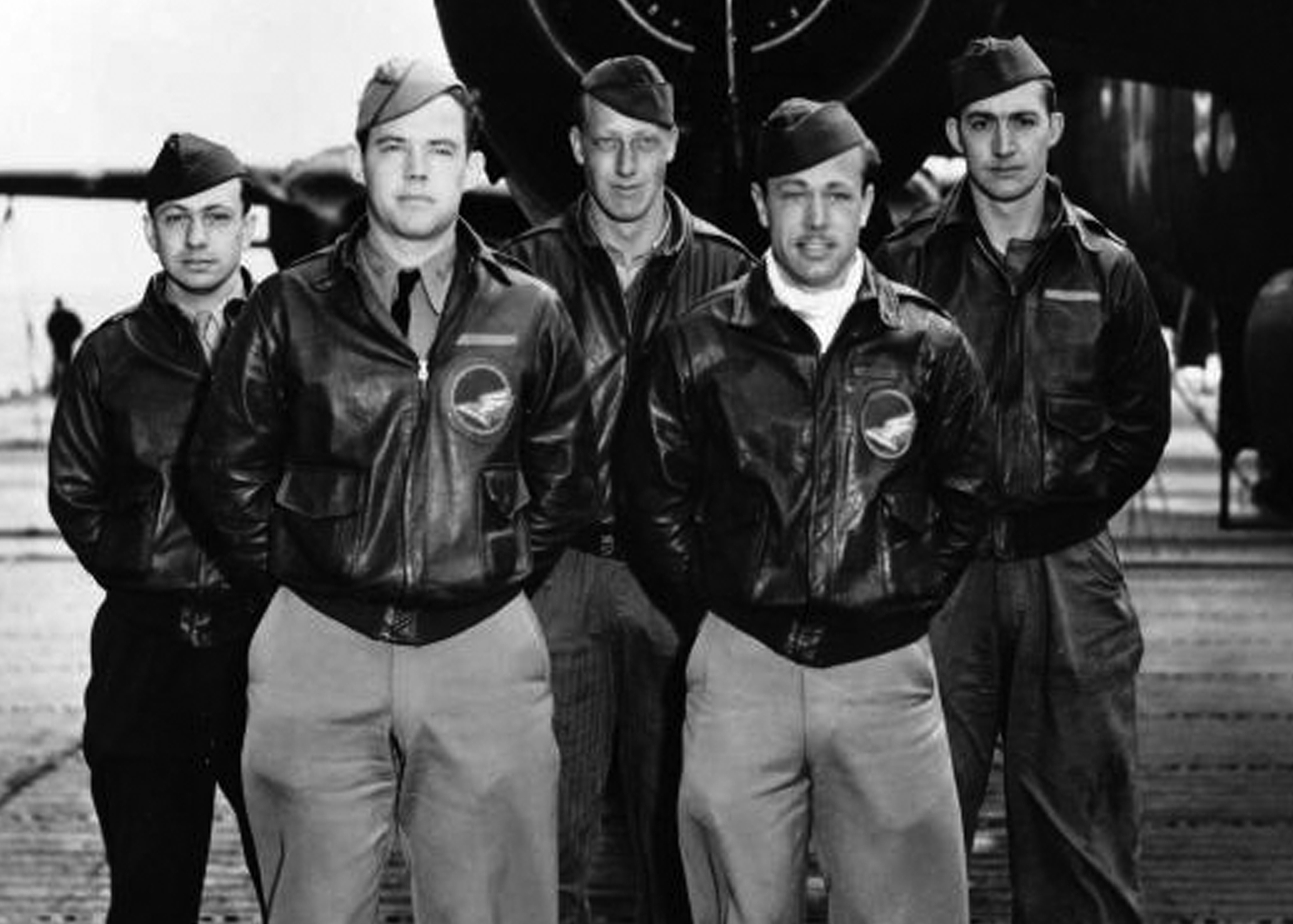 Five pilots standing in front of a plane for a group picture