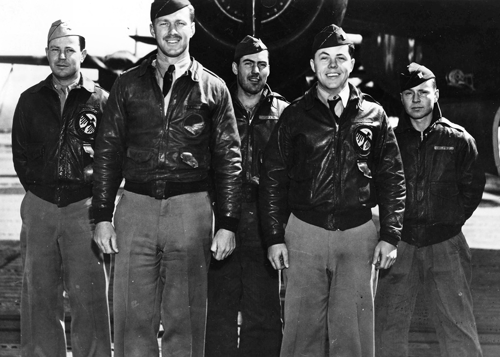 Five pilots standing in front of a plane for a group picture