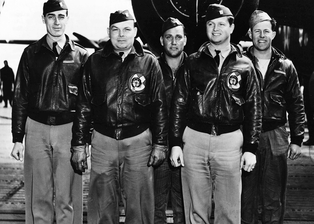 Five pilots standing in front of a plane for a group picture