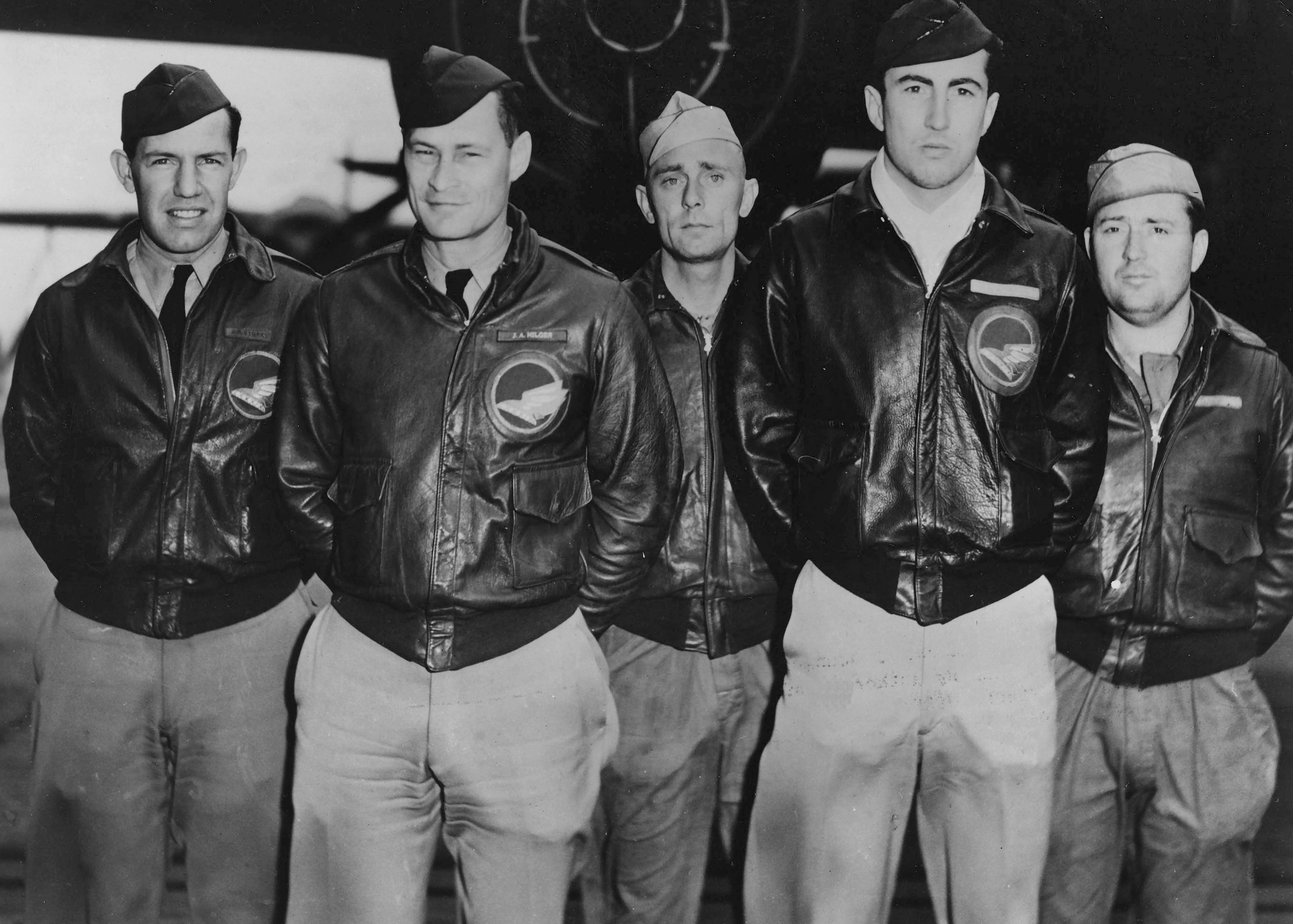 Five pilots standing in front of a plane for a group picture