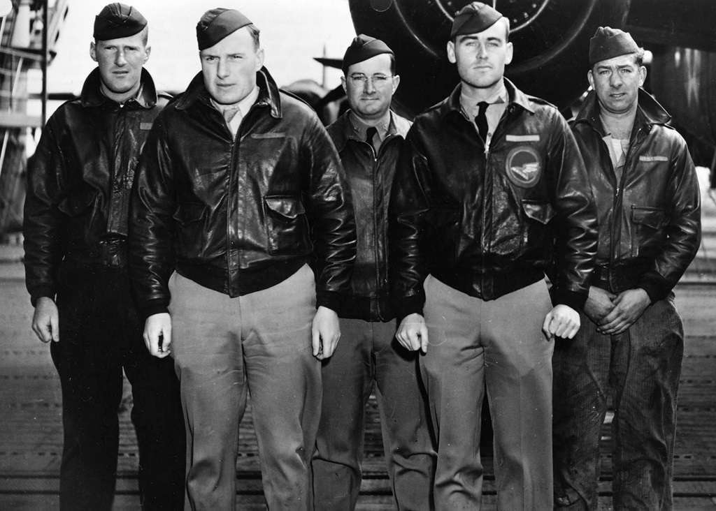 Five pilots standing in front of a plane for a group picture