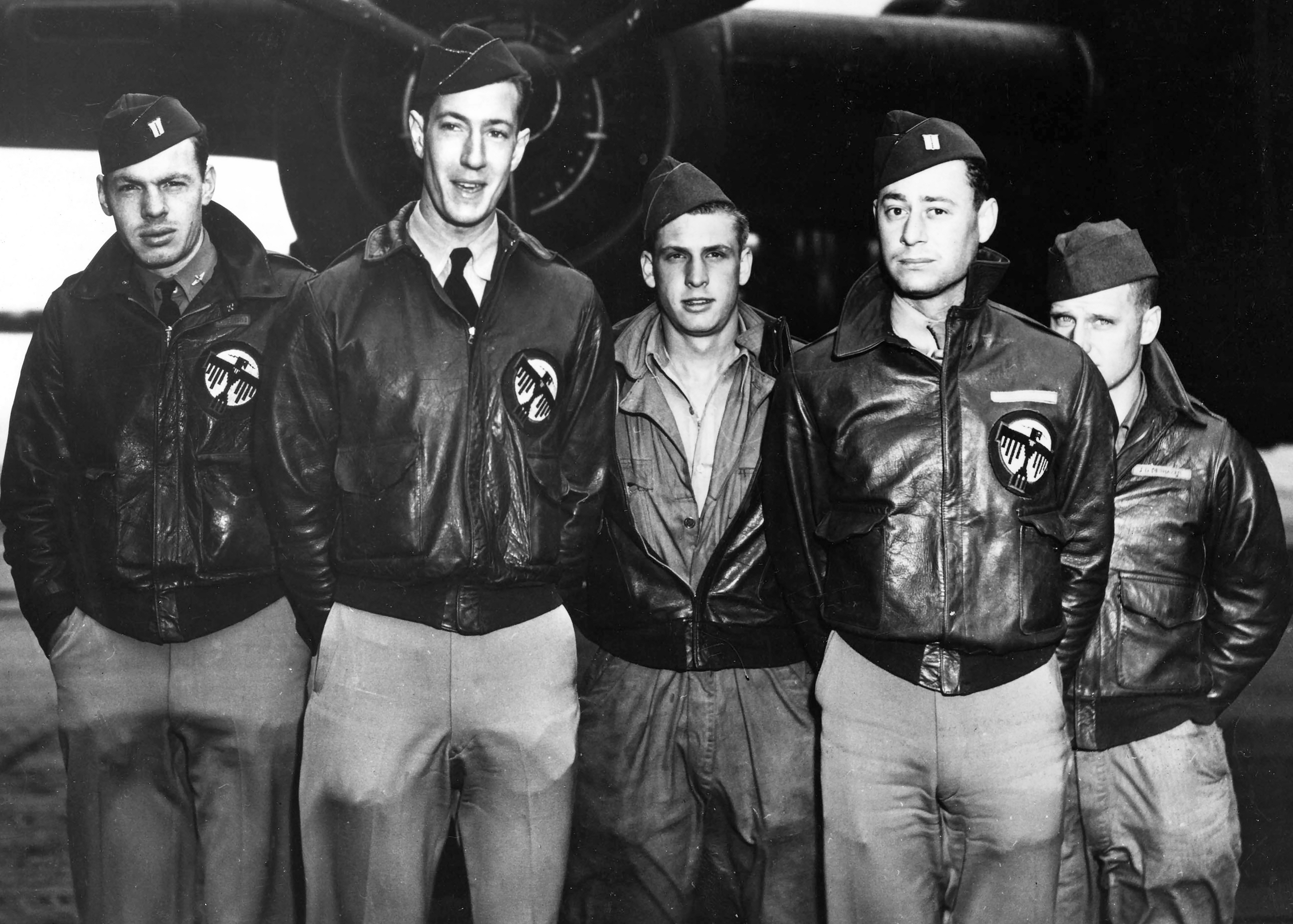 Five pilots standing in front of a plane for a group picture