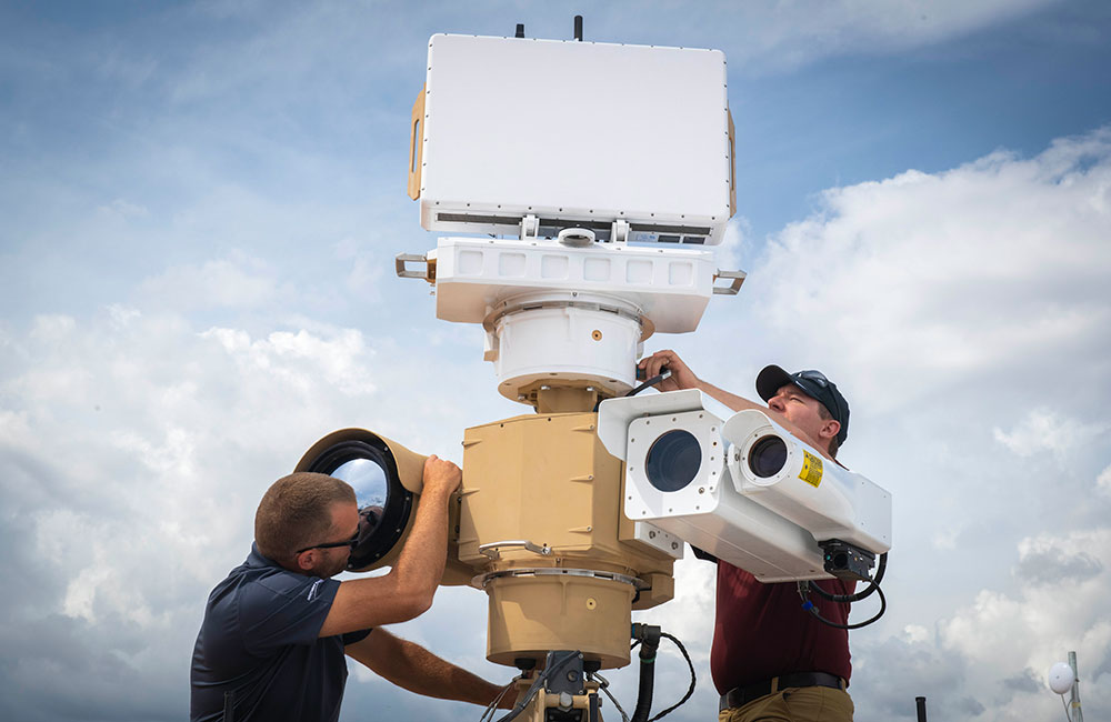 two males working on an outdoor sensor