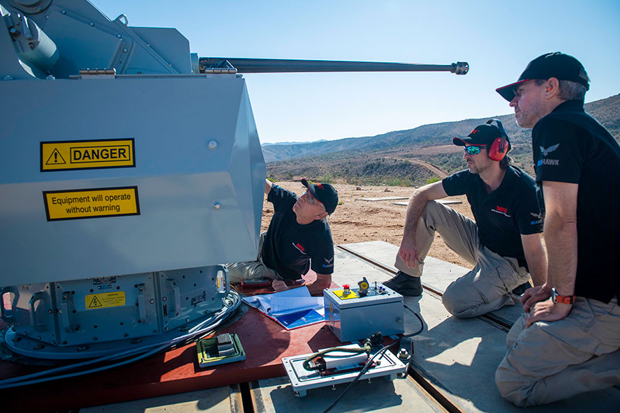 3 males working on a large gun