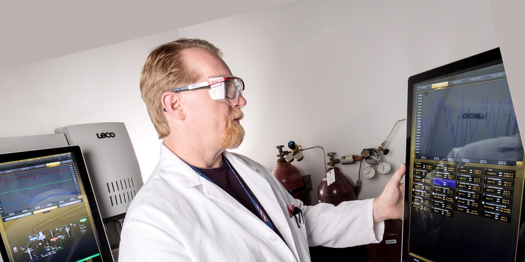 man in lab coat working on pc