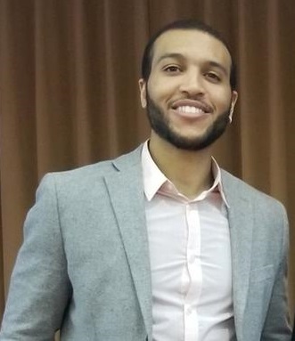 African American male smiling and wearing a suit