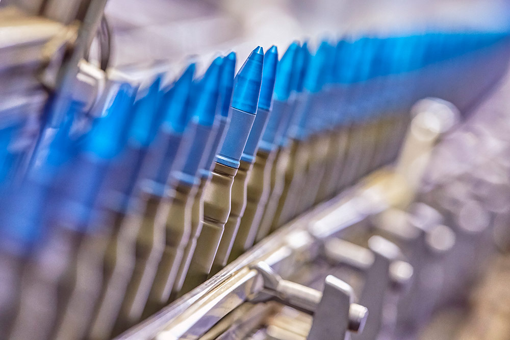 blue tipped ammunition bullets on assembly line