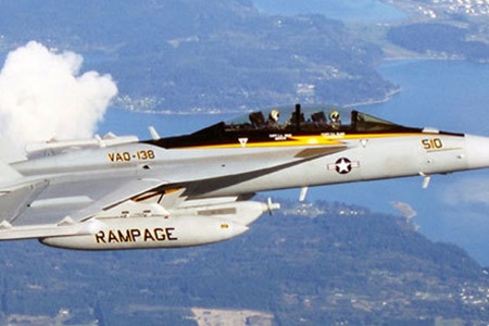 military fighter jet flying above water and land