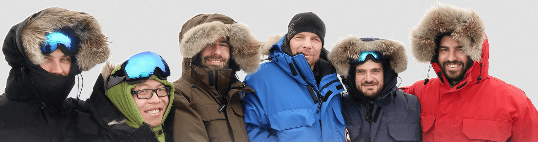 One woman and five men stand posing in winter jackets