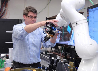 a man holds a robotic arm
