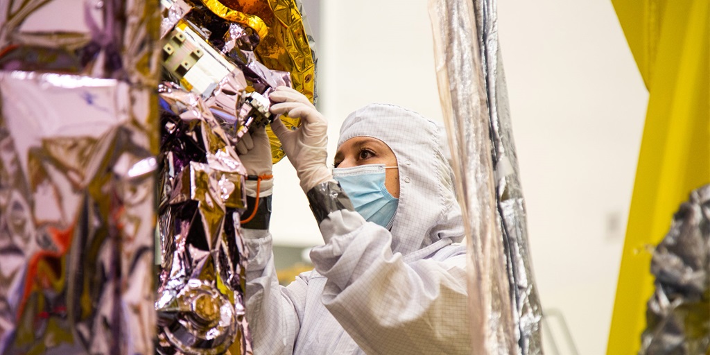 Making Everything Right: Cosmic Outfitters: Dressing Spacecraft for Mission Success Female engineer working on spacecraft
