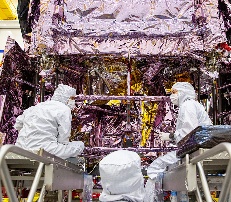 Three workers dressing spacecraft