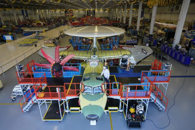 man working on aircraft in manufacturing facility