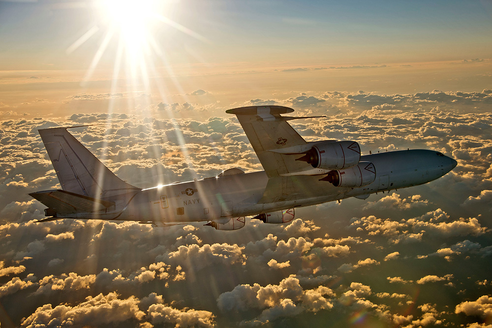 Navy plane flying above the clouds