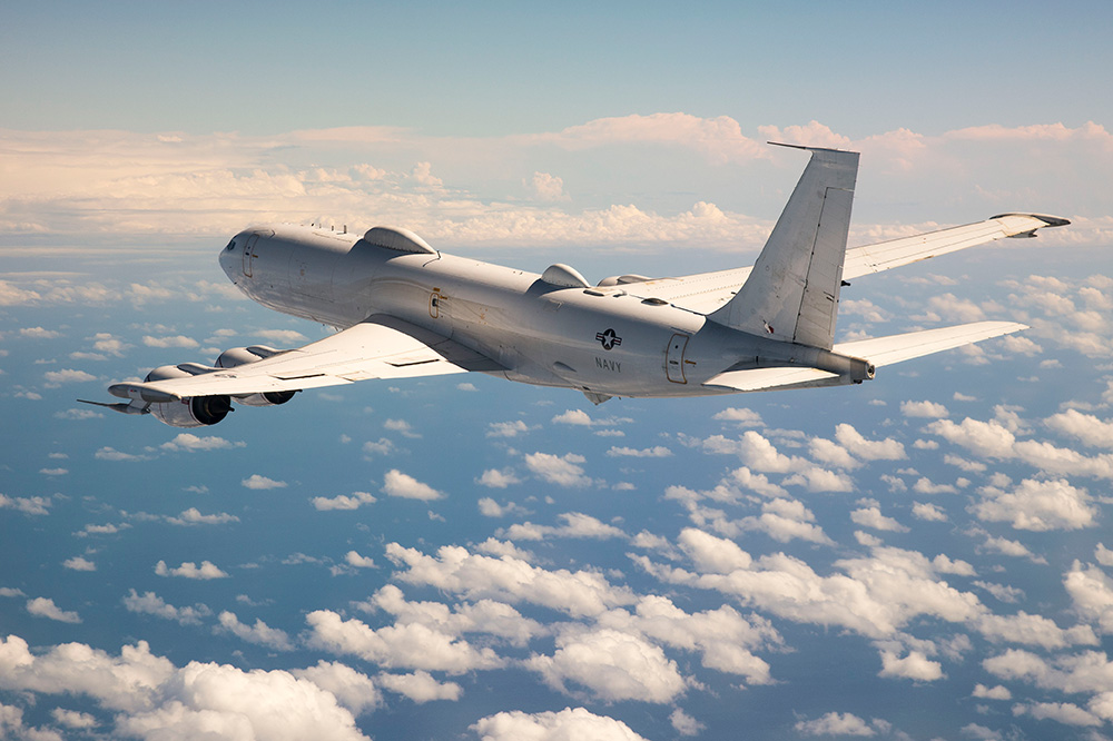 Navy plane flying above the clouds