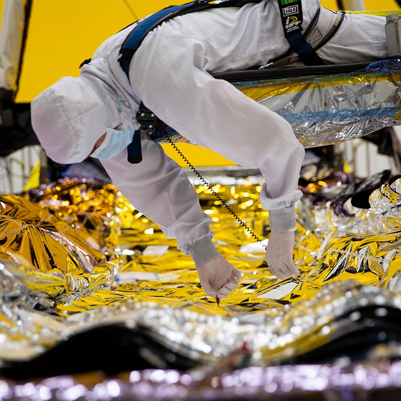 man in bunnysuit working on JWST sunshield