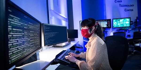 Woman wearing mask working on a computer