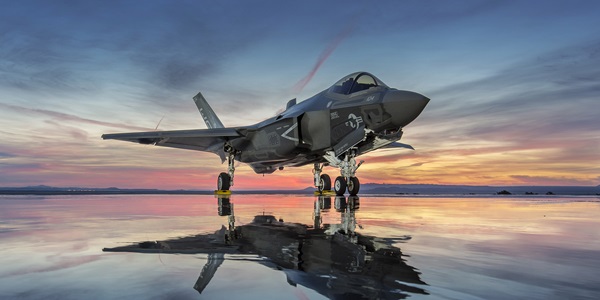 F-35 fighter jet on a dry lake bead at sunset